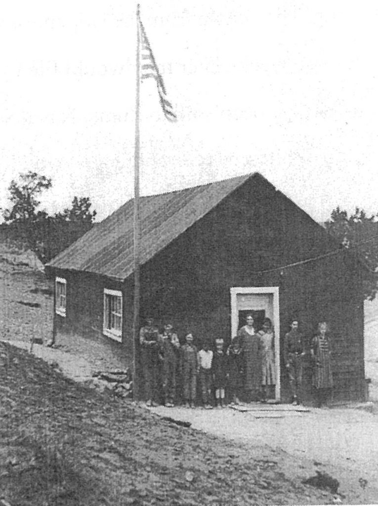 This is the first schoolhouse in Houck. It stood southwest of the mission across the puerco wash near some windmills. The boy fourth from the left (in the white shirt) is Henry Morgan.